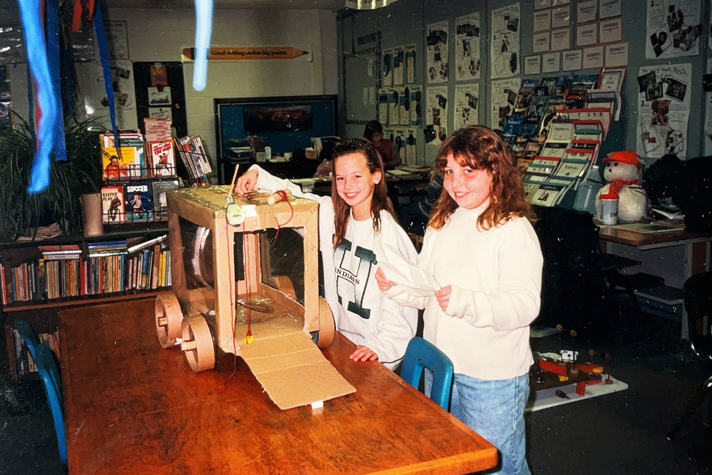 A collection of vintage Hartford Public Schools photographs featured in Hartford Rewind | Volume 2. The images include students posing with academic trophies, science classroom activities, elementary students reading and participating in class, hands-on classroom projects, cultural learning activities, CPR training, group class photos, Adult Education displays at a community event, students gathered outdoors, and various classroom and school life scenes from past decades. The photographs capture everyday moments, learning experiences, and student life throughout Hartford Public Schools' history.