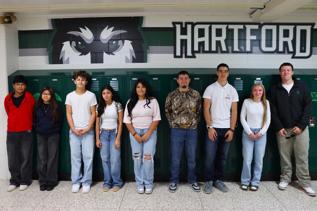 hartford high school homecoming prince and princess candidates pose infront of green lockers and a hartford husky wall decal