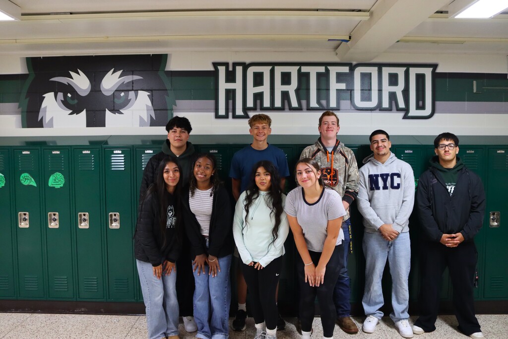 hartford high school homecoming king and queen candidates pose infront of green lockers and a hartford husky wall decal