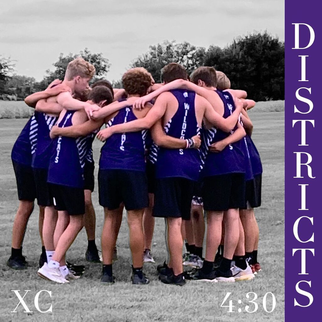 A boys’ cross-country team in blue singlets huddles with arms around one another on a grassy field, conveying unity and focus; purple “Districts” banner reads 4:30.