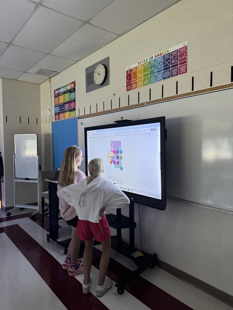 Two girls in front of promethean board.