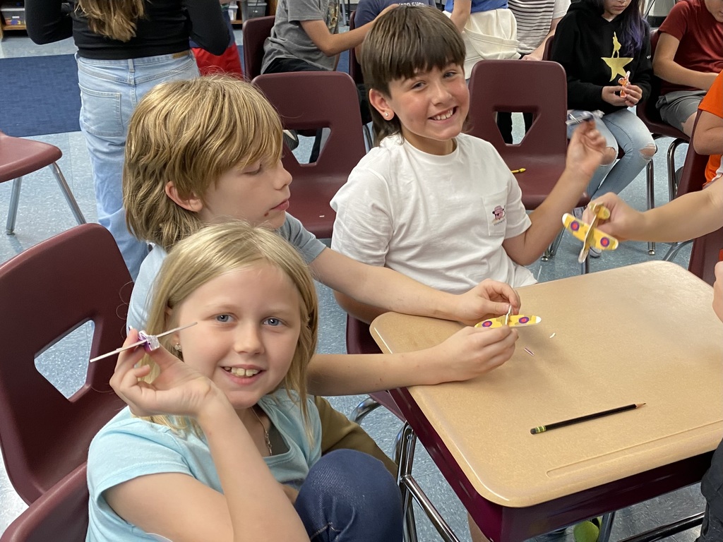 Students holding small balsa wood planes