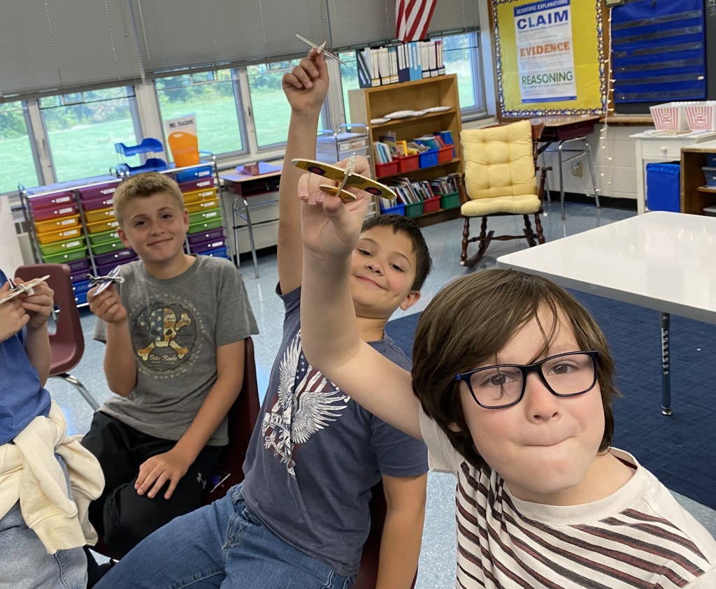 Students holding small balsa wood planes