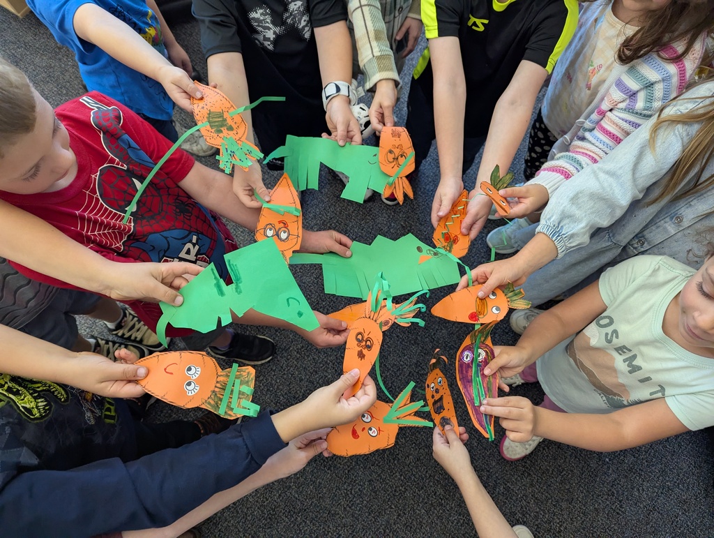 Construction paper carrots held by children