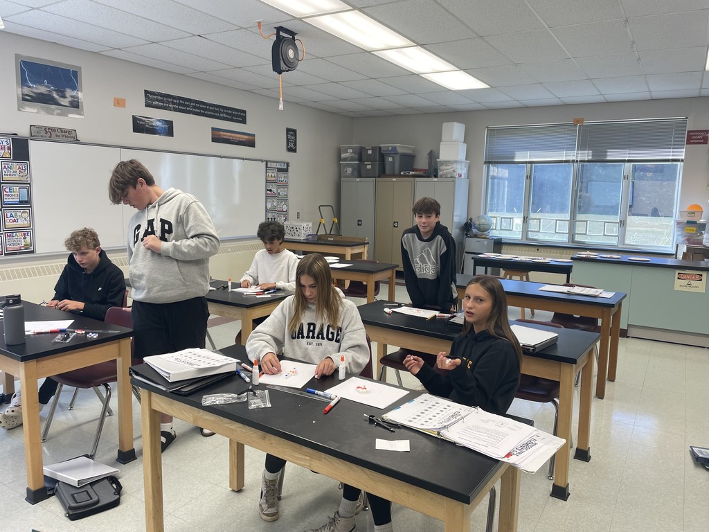 Middle school students working on tables.