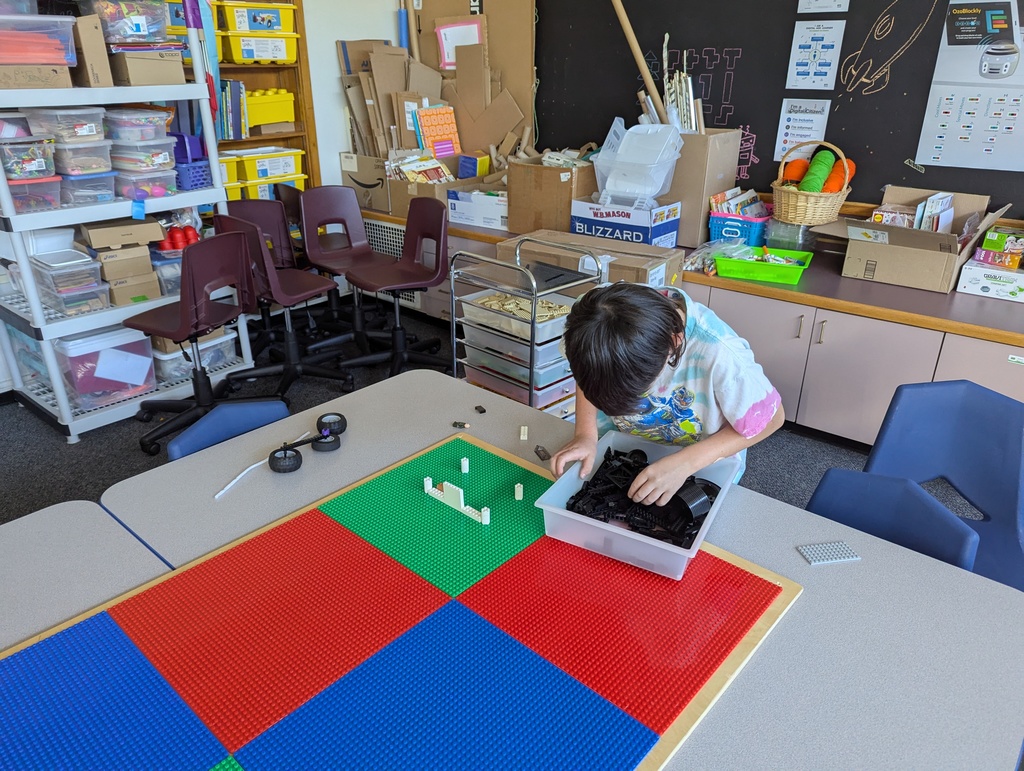 Child looking in Lego box on table