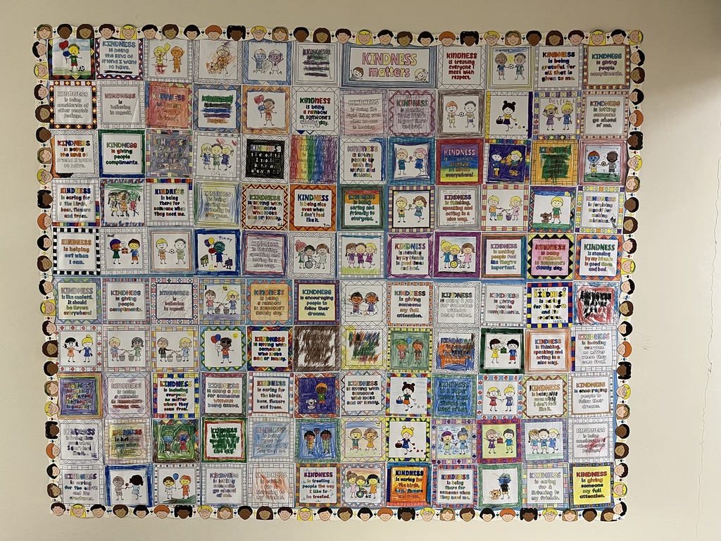 Paper quilt of kindness squares hung on a wall.