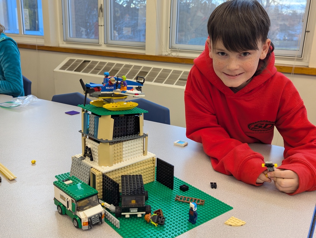 Boy next to lego house