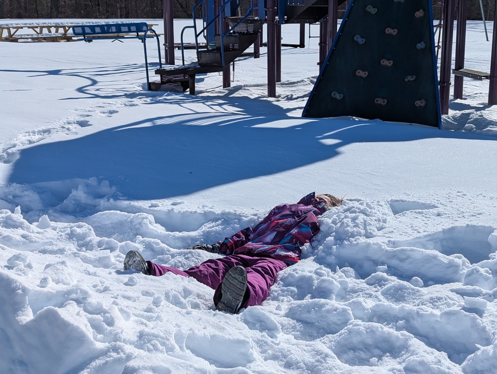 child laying in snow