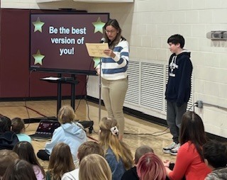 Boy at front of room getting award.