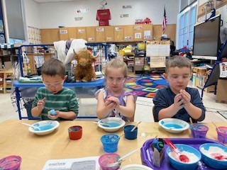 students making blue mixture wearing goggles