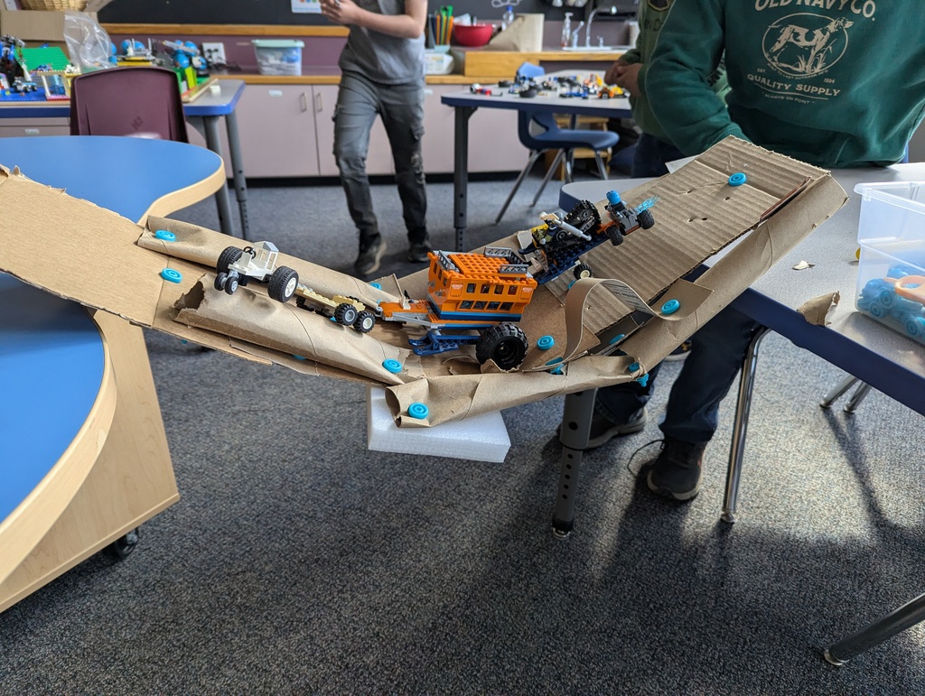 Lego vehicles on cardboard bridge