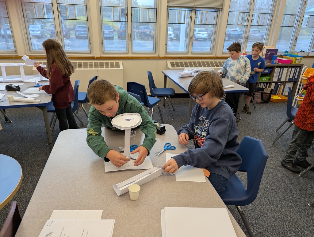 Two boys building paper sculpture