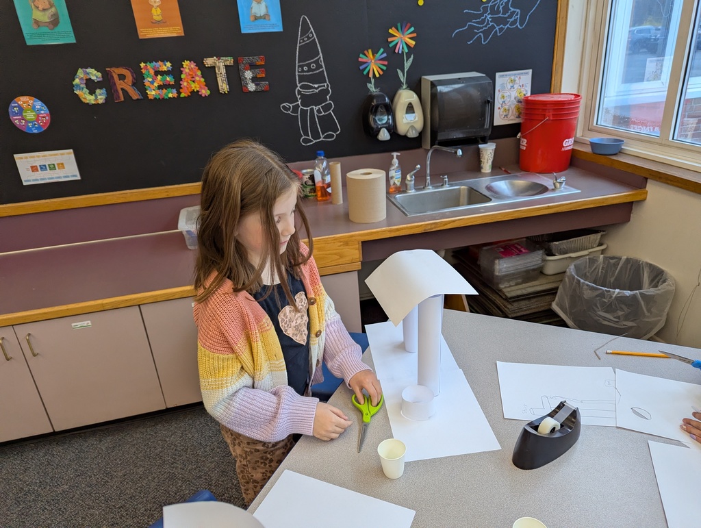 Girl at table with paper build