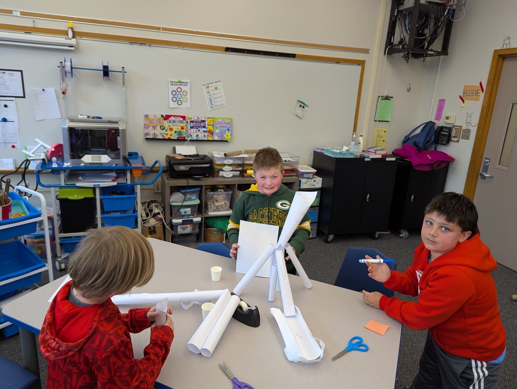 Boys at table creating with paper