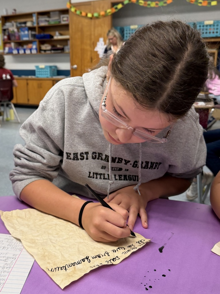 Girl wrting at desk with calligraphy pen