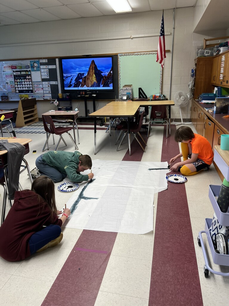 Kids drawing on paper on the floor