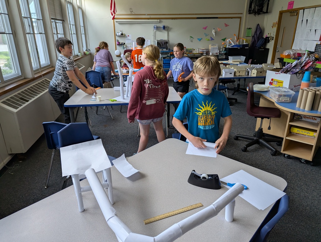 Picture of class of students working on paper roller coasters.