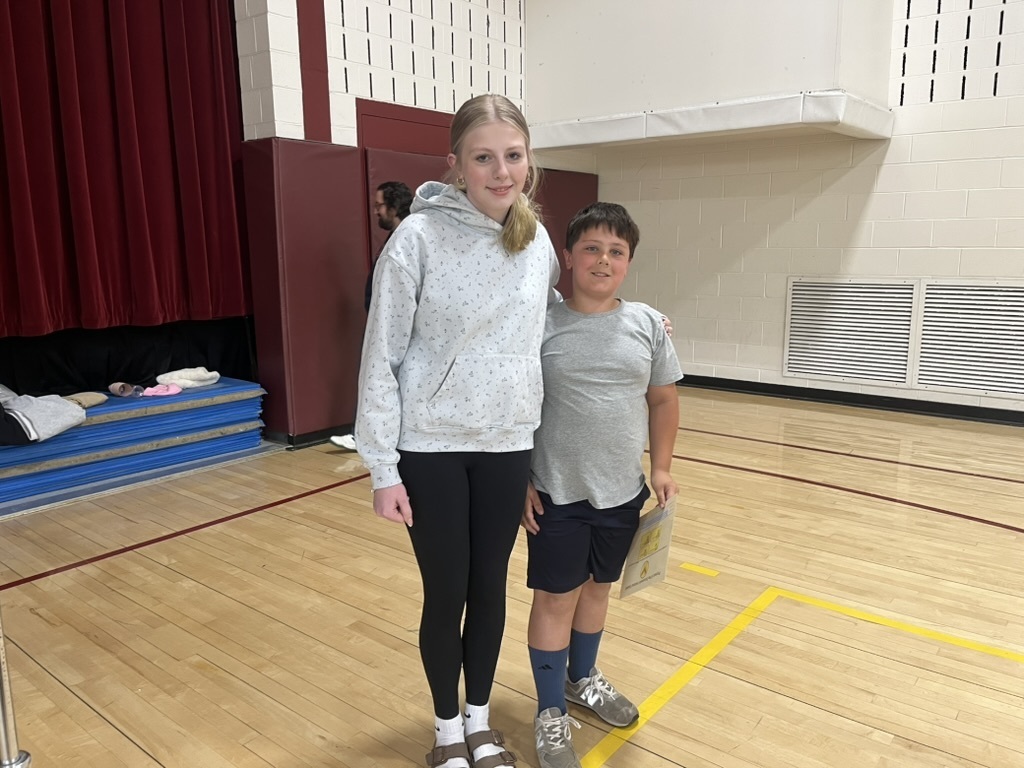 Brother and sister standing next to each other.
