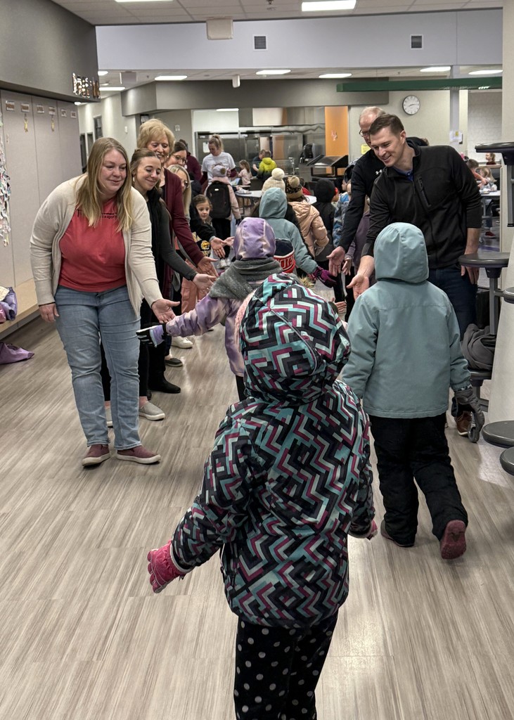 Students walking in getting high fives from community members