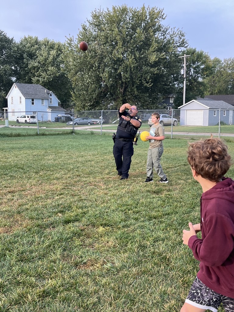 Officer playing football with students