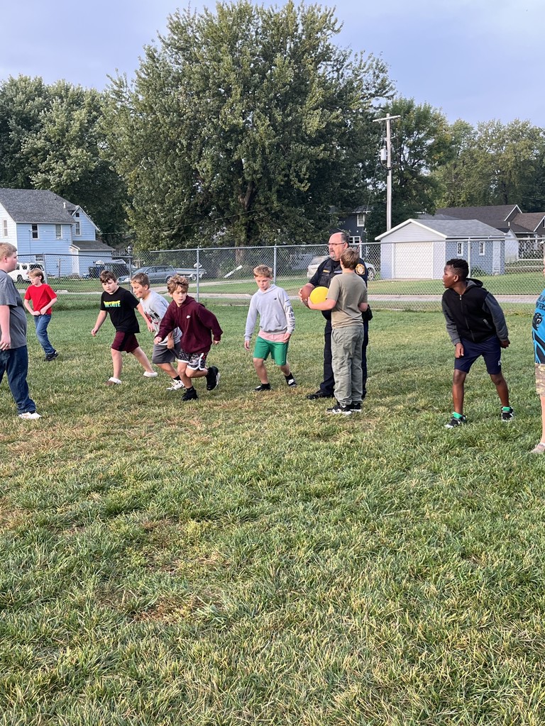Officer playing football with students