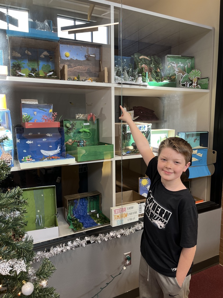 5th grader showing off biome box