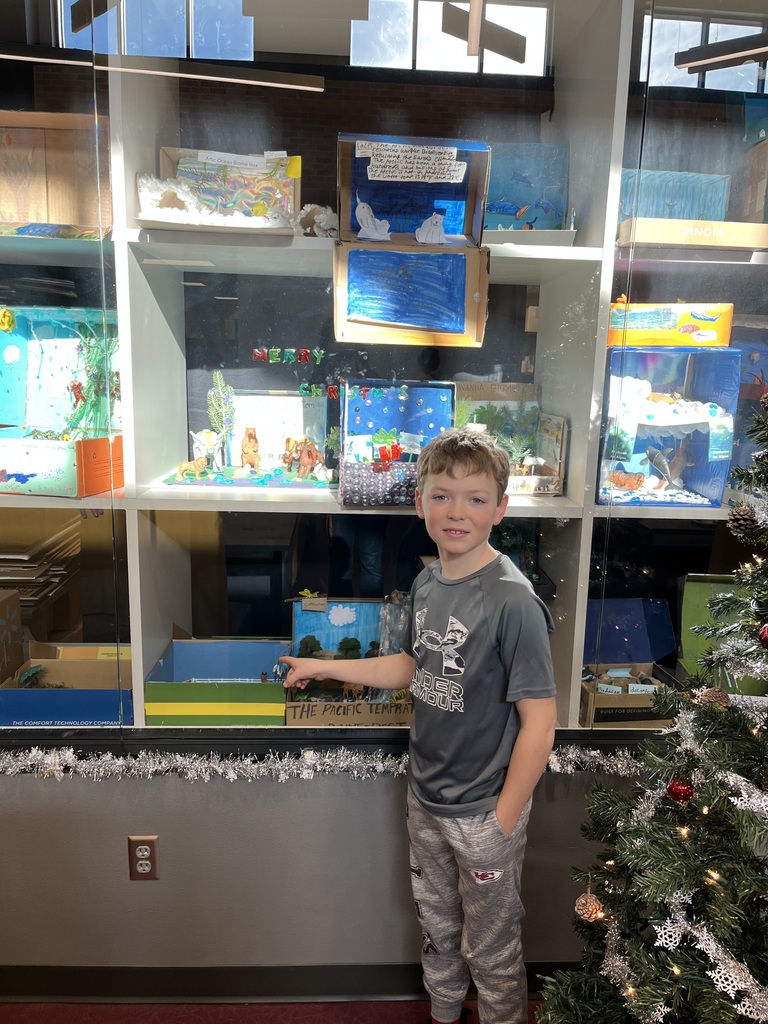 5th grader showing off biome box
