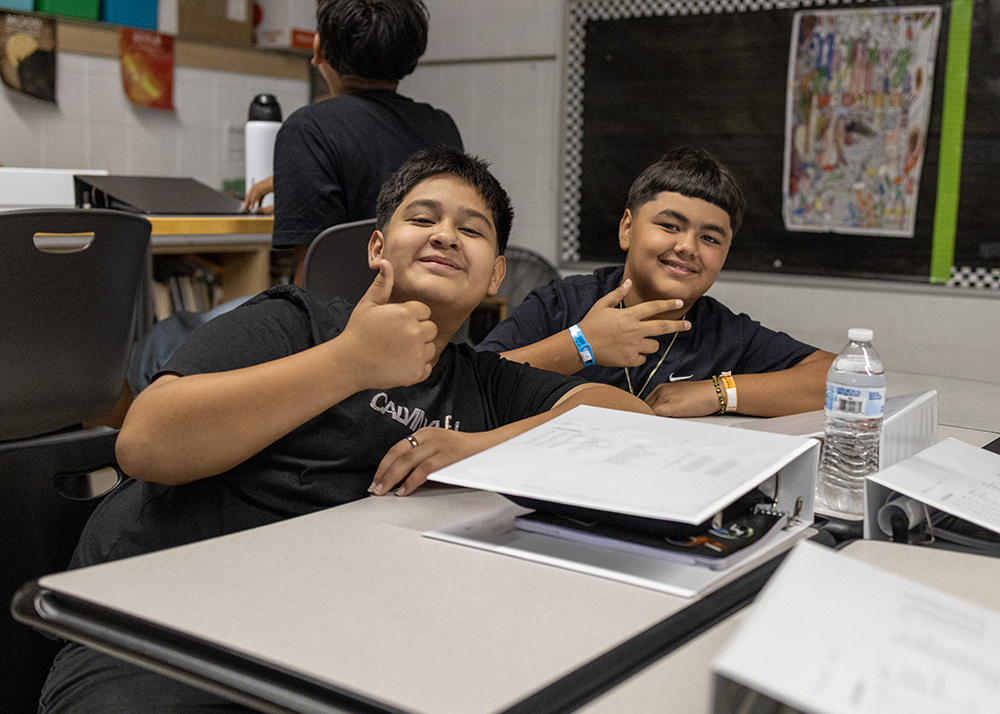 Two students smiling in classroom.