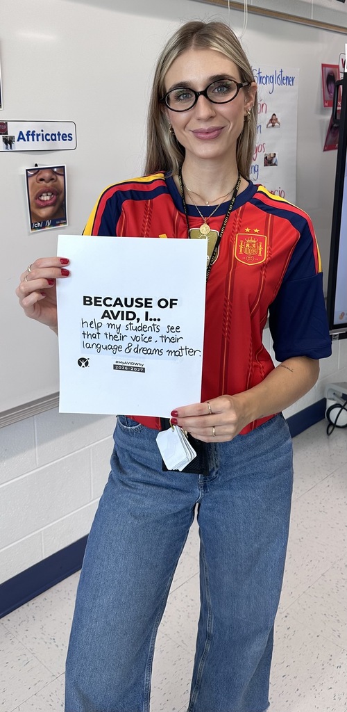 Staff with AVID Day sign in classroom.