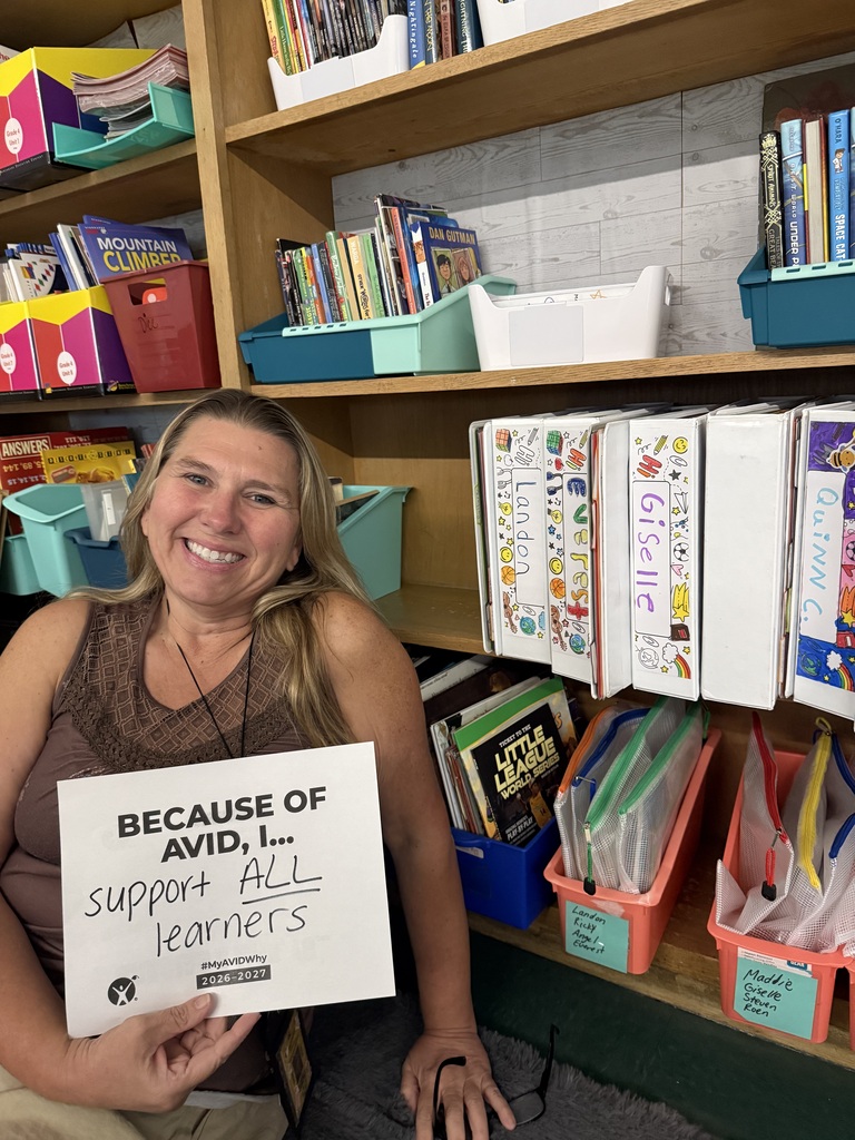 Staff with AVID Day sign in classroom.