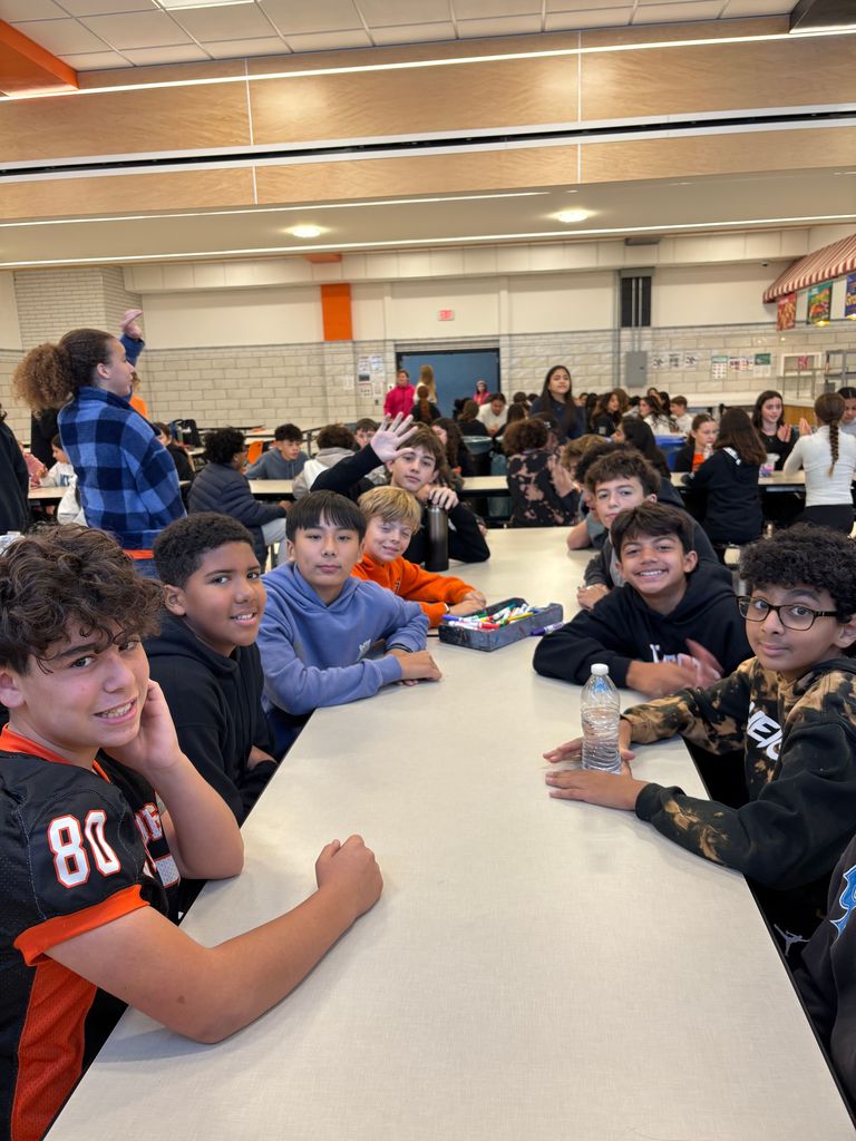 A group of boys sitting at a cafeteria table. 