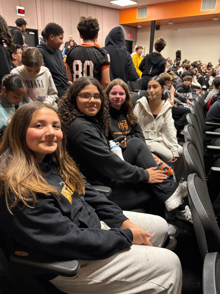 A group of girls sitting in an auditorium.