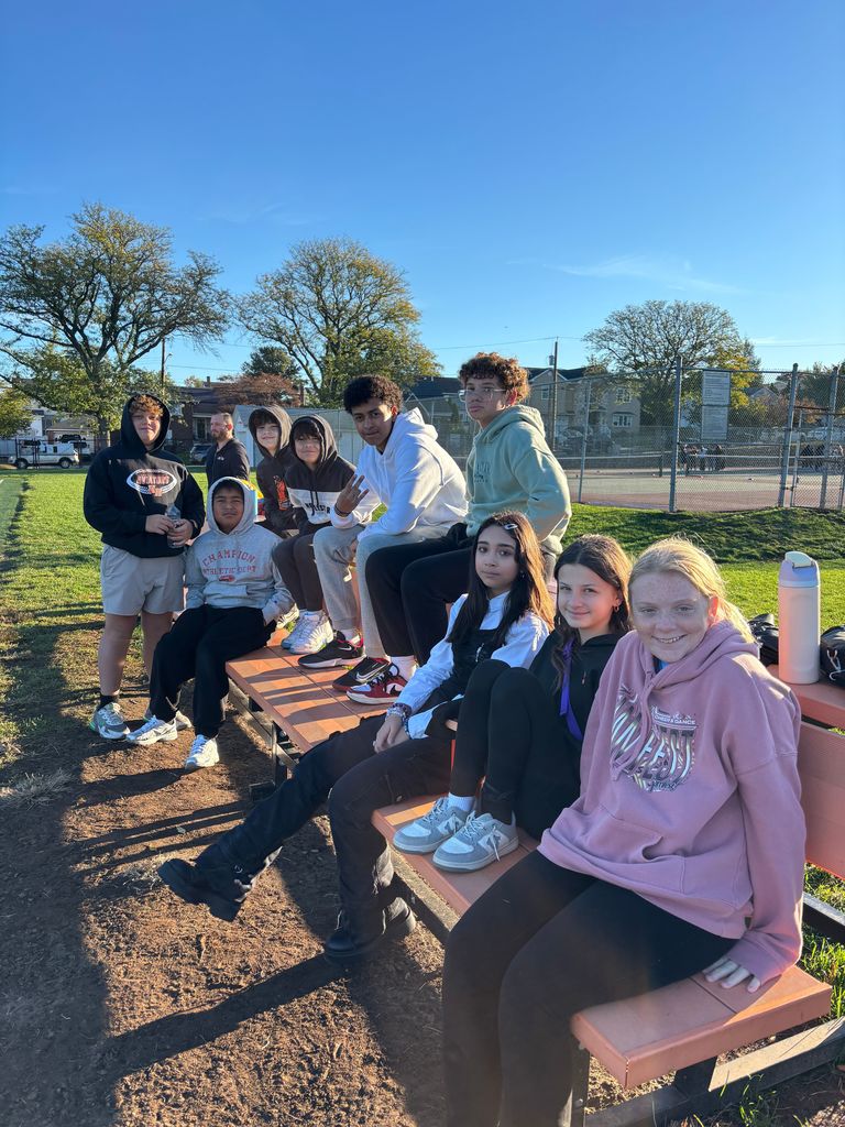A group of kids sitting on bleachers. 