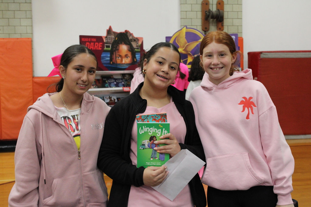 Students holding up books at the book fair.