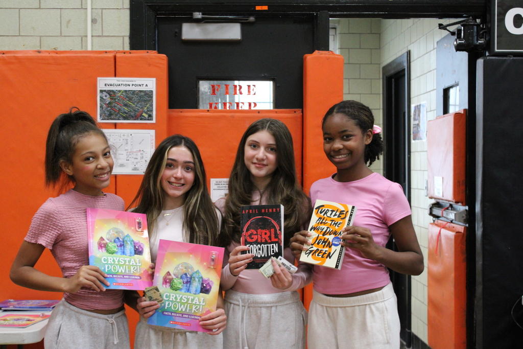 Students holding up books at the book fair.
