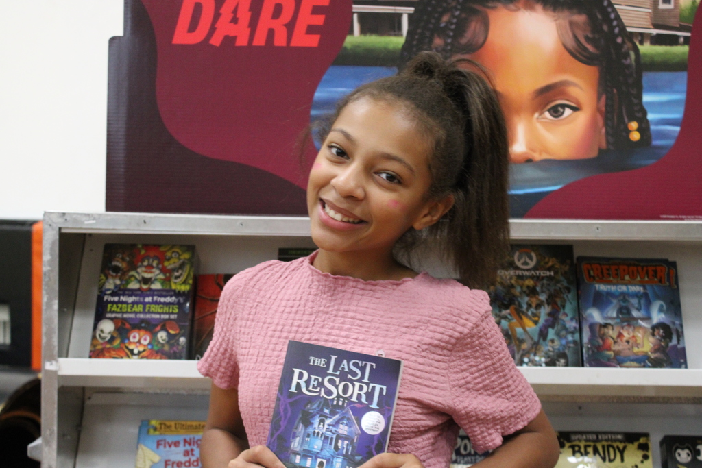 Students holding up books at the book fair.