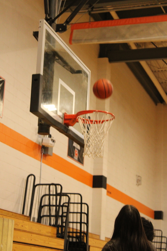 Basketball going into a hoop. 
