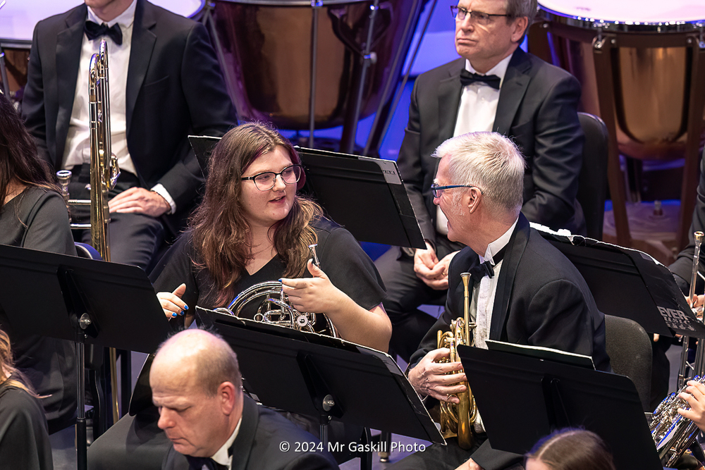 Hastings High School band students sits next to a member of the Grand Rapids Symphony