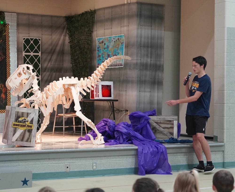 Hastings High School junior Maverik unveils a dinosaur skeleton he made from a CNC machine and wood.