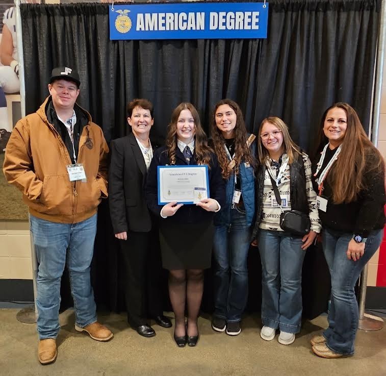 Kaylie Carl posing surrounded by friends and family