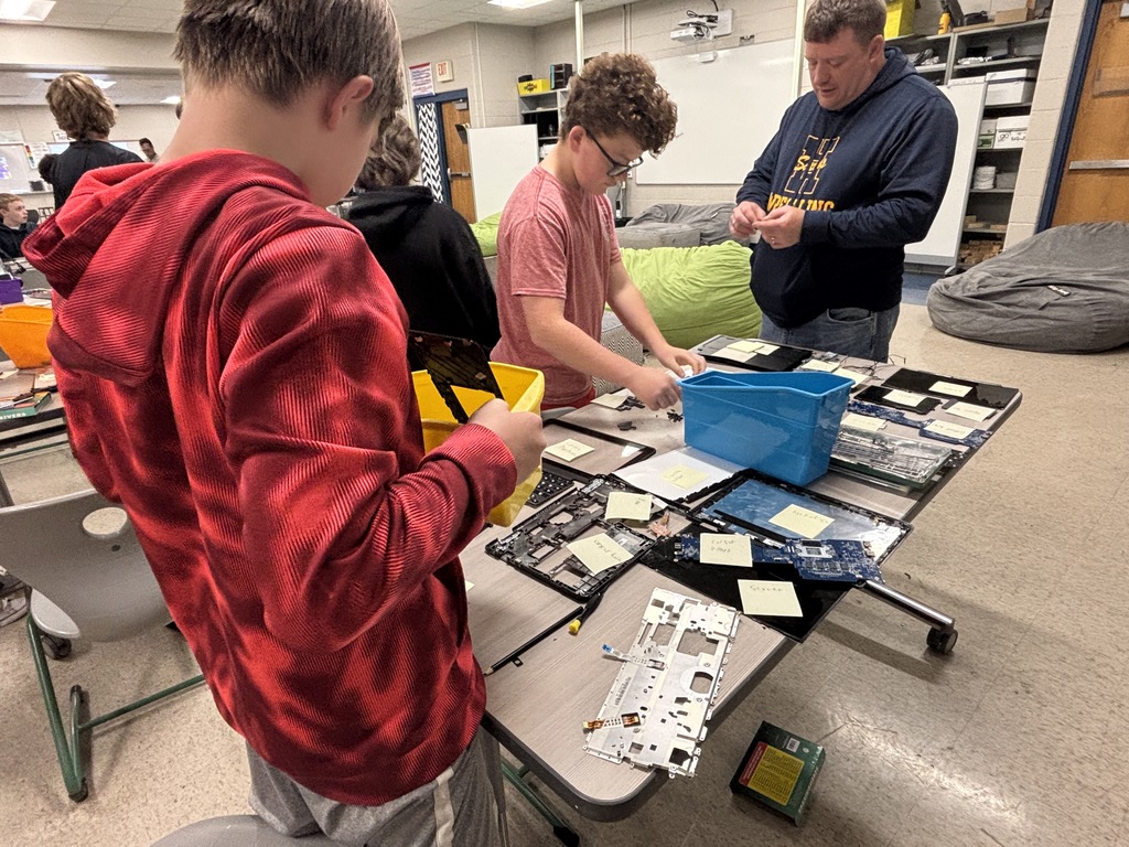 Middle school kids disassembling Chrombooks.