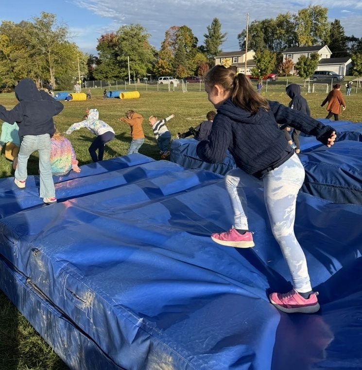 Students running over obstacles during the Rock-n-Run event at Northeastern Elementary.