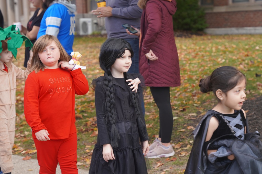 Central Elementary students walking through a tunnel of parents during the Halloween parade.