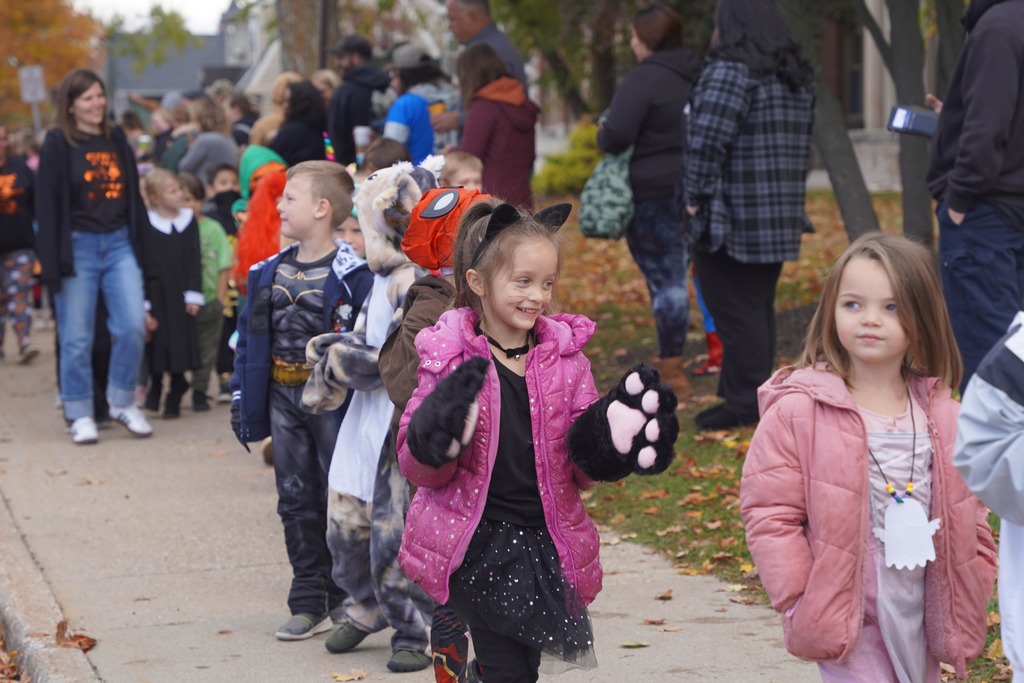 Central Elementary students walking through a tunnel of parents during the Halloween parade.