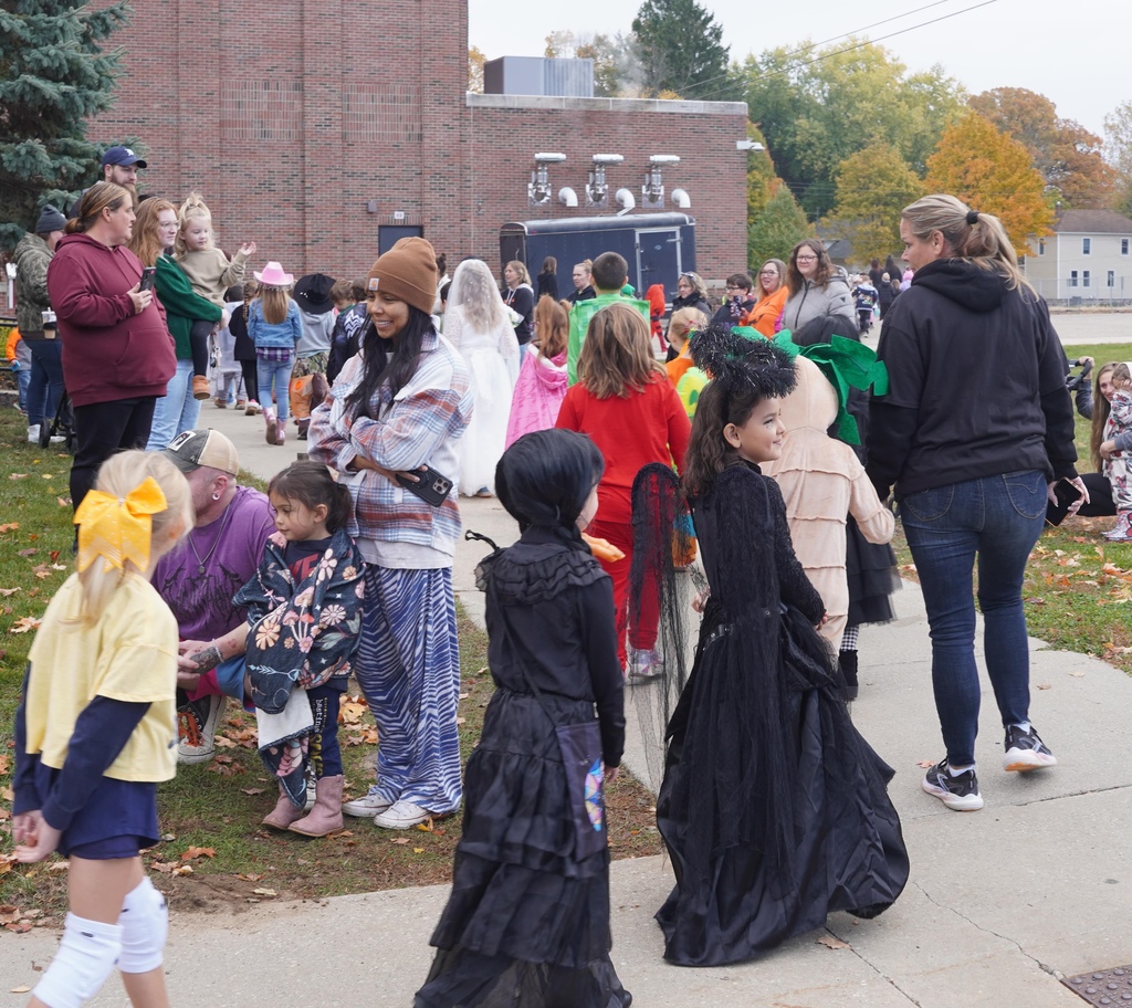 Central Elementary students walking through a tunnel of parents during the Halloween parade.