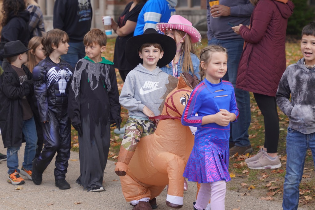 Central Elementary students walking through a tunnel of parents during the Halloween parade.