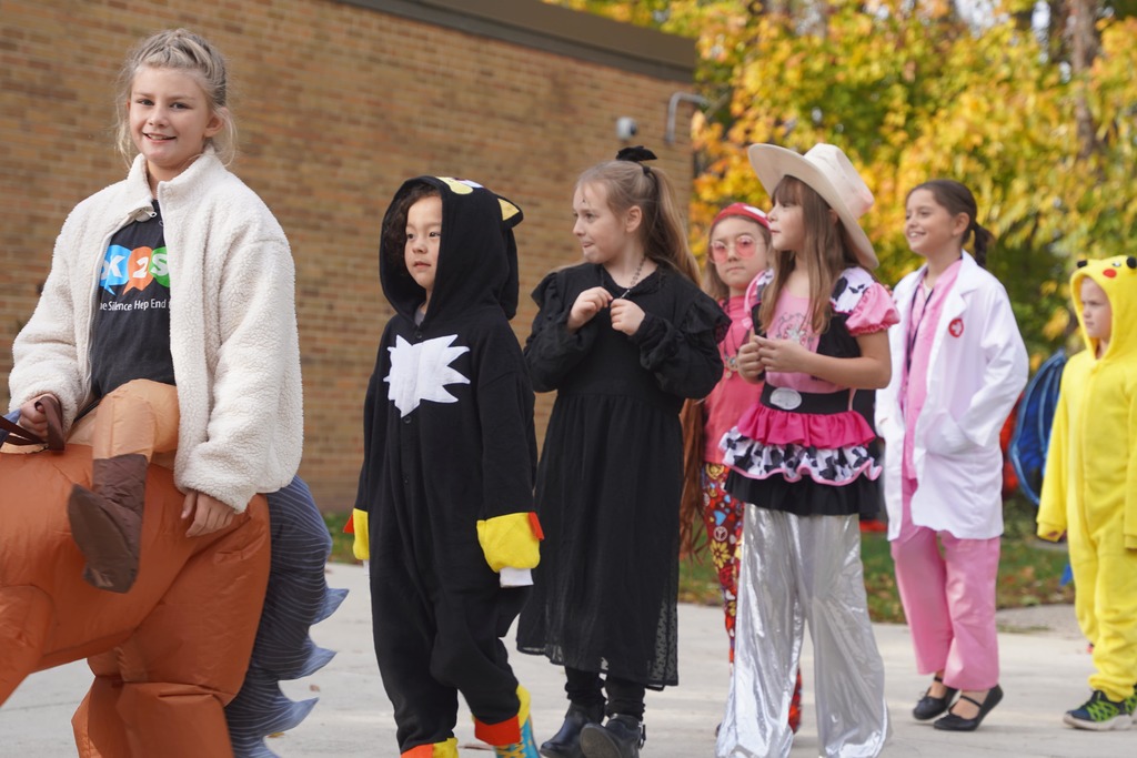 Southeastern Elementary students walking in their Halloween parade, surrounded by onlooking parents.