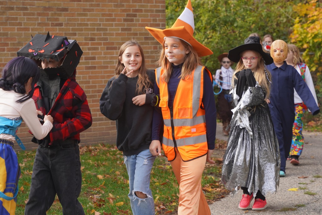 Southeastern Elementary students walking in their Halloween parade, surrounded by onlooking parents.