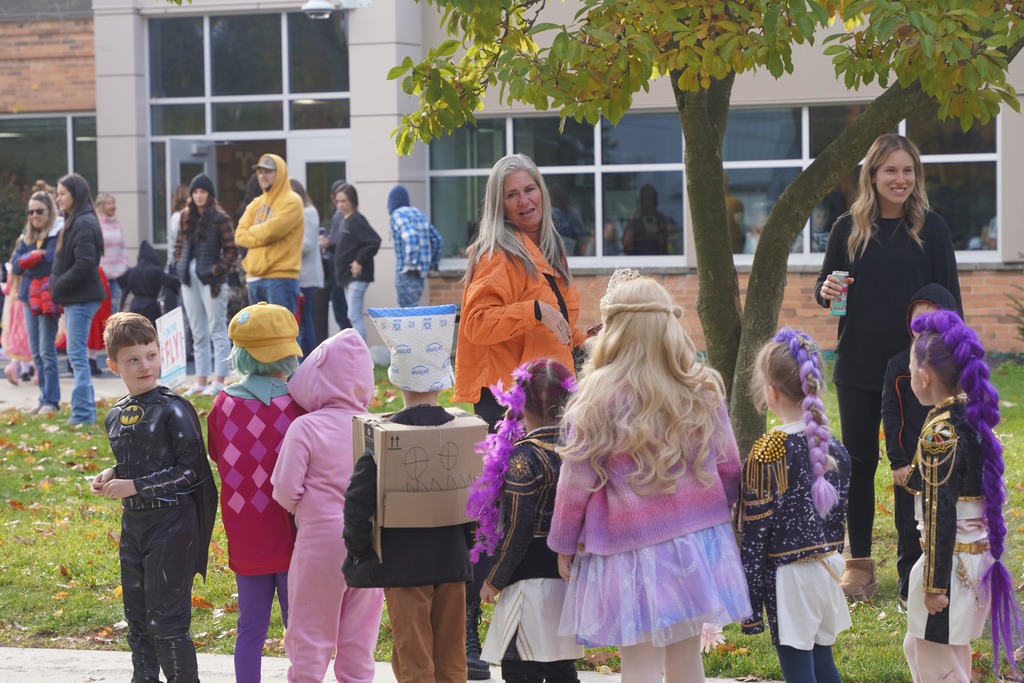 Southeastern Elementary students walking in their Halloween parade, surrounded by onlooking parents.